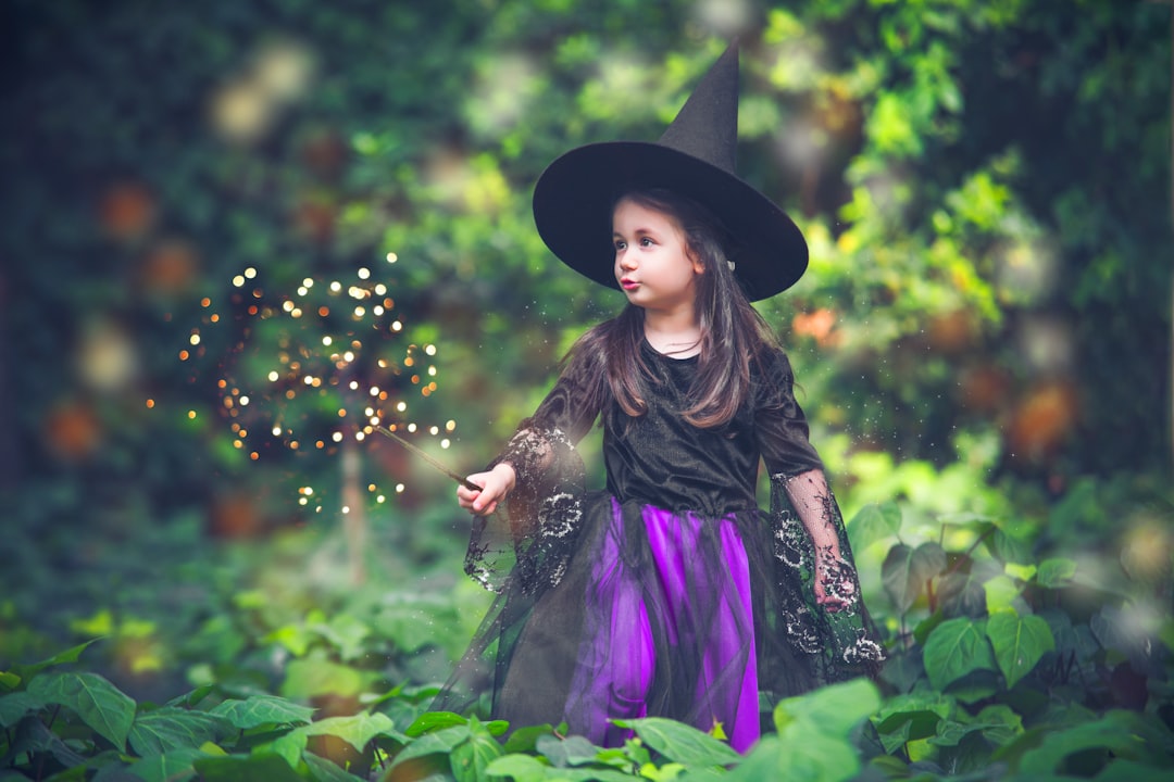 a little girl dressed in a witches costume