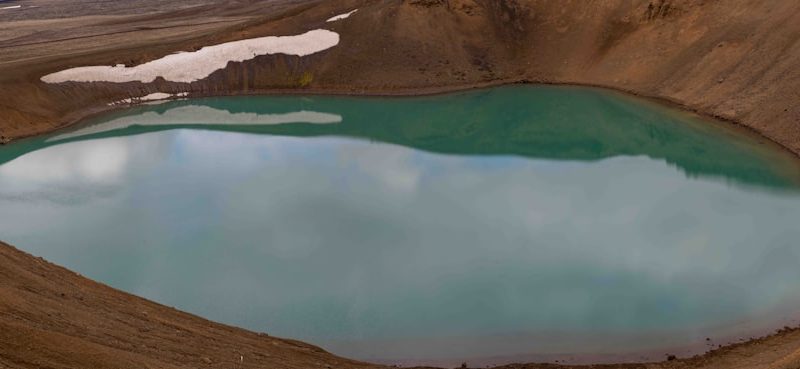 a large body of water surrounded by brown hills