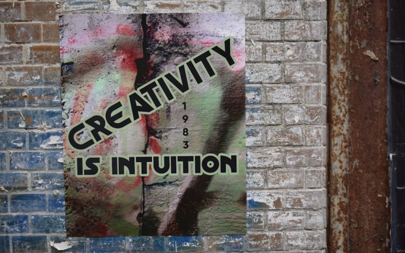 a sign on a brick wall that says creativity is institution