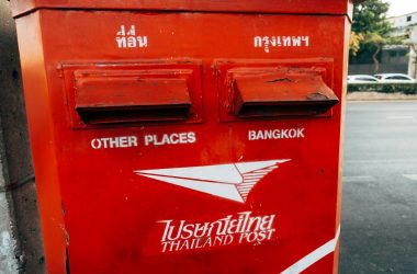 a red mailbox sitting on the side of a road