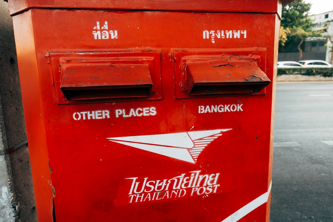 a red mailbox sitting on the side of a road