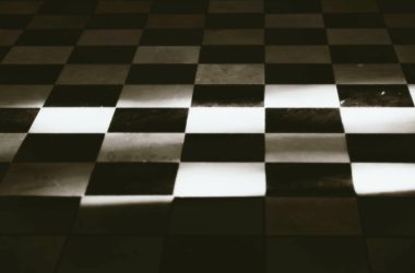 A black and white photo of a checkered floor