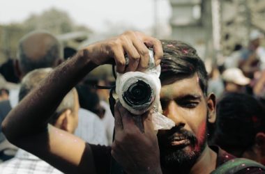 A photographer takes a picture during holi festival.