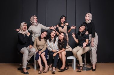 group of women sitting on black couch