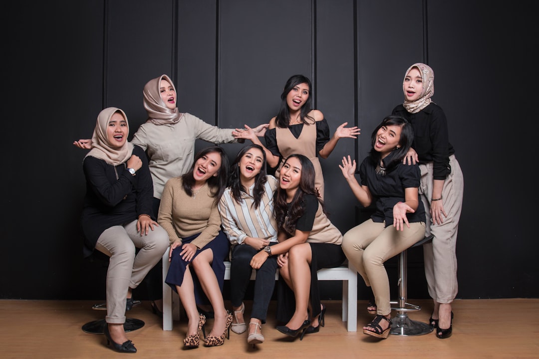 group of women sitting on black couch