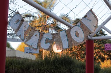 a sign that says welcome hanging from a fence