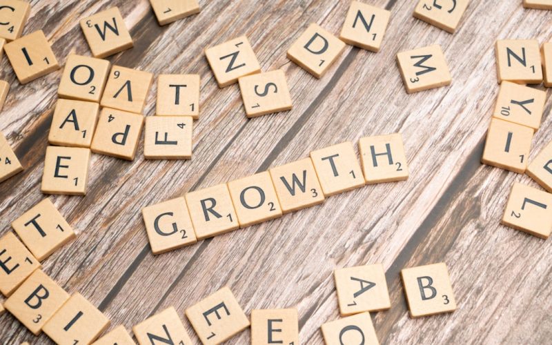 scrabbled letters spelling growth on a wooden surface