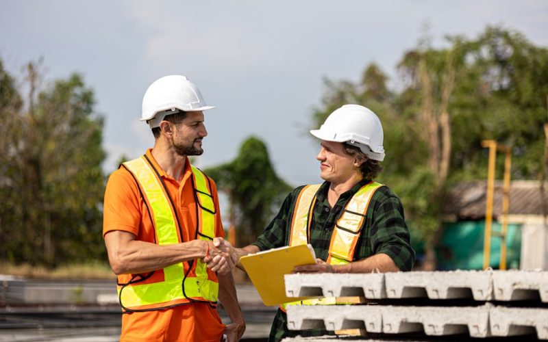 Construction workers shake hands after a deal.
