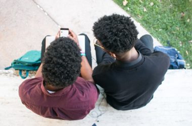 a couple of people sitting on top of a bench
