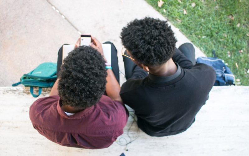 a couple of people sitting on top of a bench