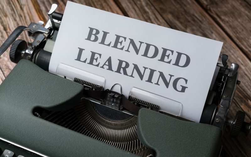 a close up of a typewriter with a sign that reads blended learning