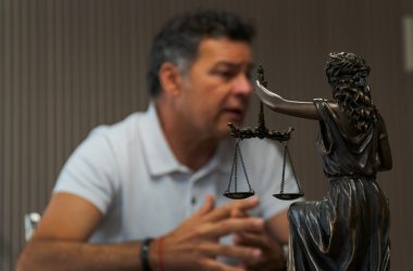 A man sitting at a table in front of a statue