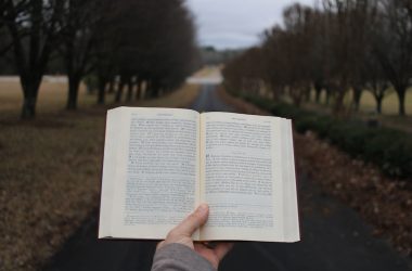 a person holding an open book in their hand