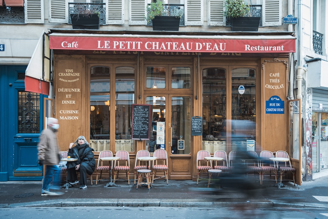 a couple of people sitting at a table outside of a restaurant
