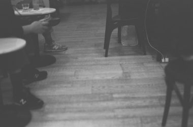 a black and white photo of a person sitting at a table
