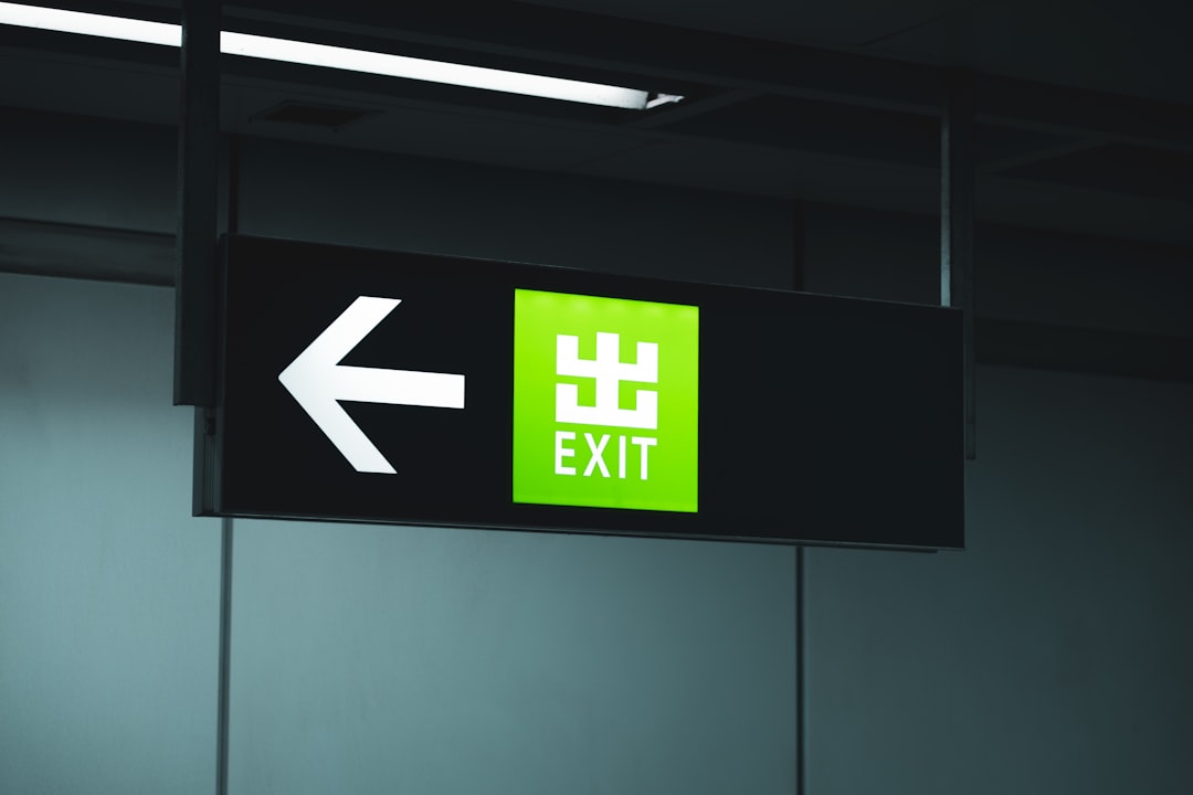 a green exit sign hanging from the ceiling